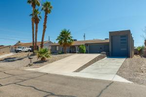 a house with a blue garage and palm trees at Coral Havasu Vacation in Lake Havasu City