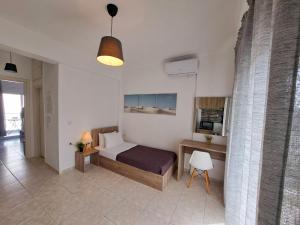 a bedroom with a bed and a desk in a room at Mitende Apartments in Kallithea Halkidikis