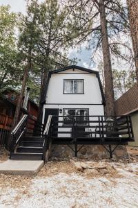 a tiny house in the woods with stairs and a window at Big Bear Pine Haven Cabin Hot Tub Games in Sugarloaf