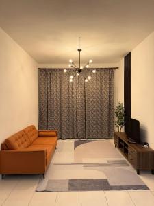 a living room with a couch and a television at Barakah Sufi Home Stay Apartment Cameron in Tanah Rata