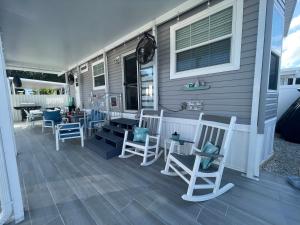 a porch with chairs and tables on a house at Casa Seahorse in Key Largo