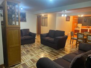 a living room with two couches and a kitchen at Espacioso y comodo departamento in Puno