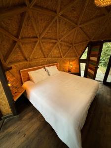 a large white bed in a room with a ceiling at Awako Glamping in Moniquirá