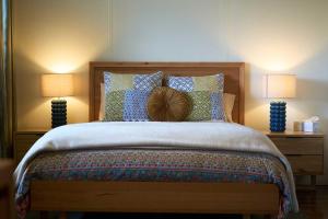 une chambre avec un grand lit avec deux lampes dans l'établissement Rosecliffe Farm Cottages, à Pomona