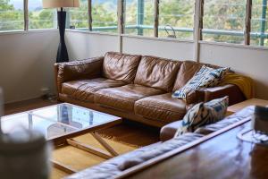 - un salon avec un canapé brun et une table en verre dans l'établissement Rosecliffe Farm Cottages, à Pomona