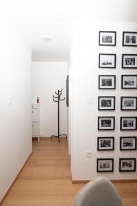 a hallway with black and white pictures on a wall at Birkin Casa- Prime Location in Novi Sad