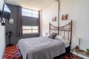 una camera da letto con un letto e una grande finestra di Apart-Hotel "El Lago" a Guatemala