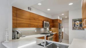 a kitchen with stainless steel appliances and wooden cabinets at Courtside Contemporary in Rancho Mirage