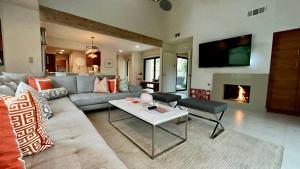 a living room with a couch and a fireplace at Courtside Contemporary in Rancho Mirage +23 photos