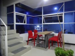a dining room with a table and red chairs at hostal lecher in Iquique