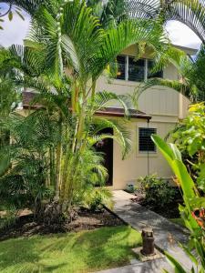 una palmera delante de una casa en Tiki Hale Lua at the Surf and Racquet Club, en Kailua-Kona