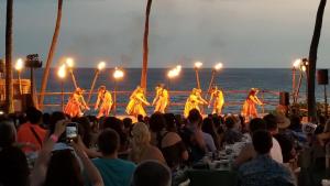 un grupo de personas viendo a un grupo de bailarines en la playa en Tiki Hale Lua at the Surf and Racquet Club, en Kailua-Kona 65 fotos más
