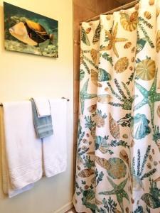 y baño con cortina de ducha y toallas. en Tiki Hale Lua at the Surf and Racquet Club, en Kailua-Kona