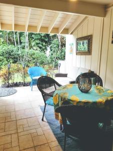 Un patio con una mesa y sillas y un sofá. en Tiki Hale Lua at the Surf and Racquet Club, en Kailua-Kona