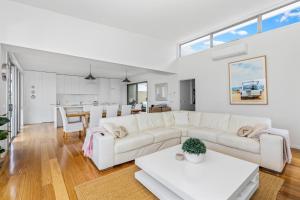 a living room with a white couch and a table at Grandview on Bayview in Inverloch