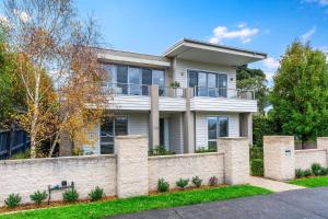 a house with a brick fence in front of it at Grandview on Bayview in Inverloch