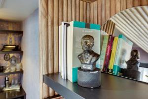 a shelf with books and a bust on it at The Salome - ADA Accessible at The Louie Boutique Motel, Walk to Everything! Dog Friendly! in Newport +29 photos