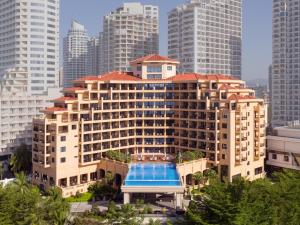 a large building with a swimming pool in a city at Sanya Golden Phoenix Seaview Hotel in Sanya