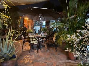 einen Tisch und Stühle mit Sonnenschirm in einem Garten in der Unterkunft Mendoza’s GUEST HOUSE in Santa Ana