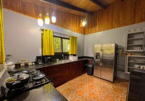 a kitchen with a stainless steel refrigerator and cabinets at La Casa de Piedra in Puerto Jiménez +46 photos