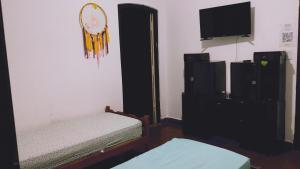 een kamer met 2 bedden, een televisie en een spiegel bij Sol de la cumbre in La Cumbre