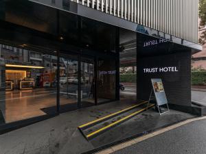 a first hotel building with a sign in front of it at Trust Hotel in Hiroshima