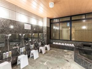 a public bathroom with sinks and white toilets at Trust Hotel in Hiroshima
