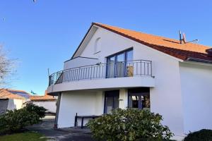 a white house with a balcony on top of it at Ferienwohnung in Burhave in Burhave