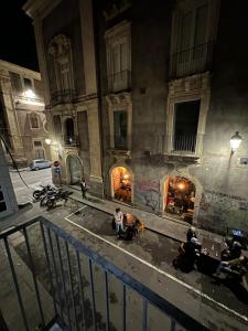 un grupo de personas sentadas frente a un edificio por la noche en Agata House, en Catania 22 fotos más