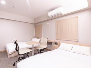 a hospital room with two beds and a table and chairs at Trust Hotel in Hiroshima +106 photos