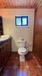 a bathroom with a toilet and a window at Casa cerca de Ajijic in Ixtlahuacán de los Membrillos +29 photos
