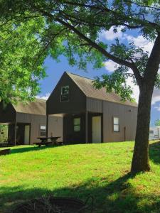 Un granero con un árbol delante en Riverfront Getaway Cabin #2 - Sleeps 5, en Stockton