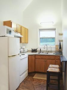 Una cocina con un refrigerador blanco y un fregadero. en Riverfront Getaway Cabin #2 - Sleeps 5, en Stockton