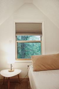 1 dormitorio con ventana, cama y mesa en Riverfront Getaway Cabin #2 - Sleeps 5, en Stockton