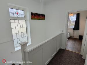 a hallway with two windows and a stair case at 2 Bedroom Flat in Quinton