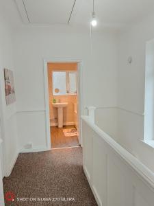 a white bathroom with a sink and a window at 2 Bedroom Flat in Quinton