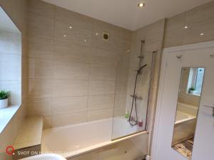 a bathroom with a shower with a tub at 2 Bedroom Flat in Quinton +7 photos