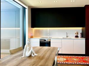 Un comedor con una mesa y una cocina. en 1BR with Balcony Close to Ferry by Zodiak Stays, en Auckland