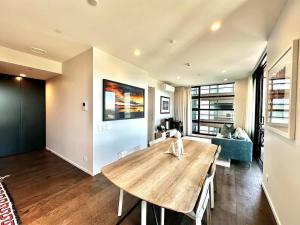 Una sala de estar con una mesa de madera y un sofá. en 1BR with Balcony Close to Ferry by Zodiak Stays, en Auckland