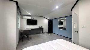 een slaapkamer met een bed en een bureau erin bij Sokcho Pine View Hotel in Sokcho +22 foto's