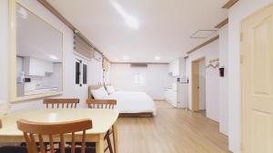 een kamer met een bed, een tafel en stoelen bij Sokcho Pine View Hotel in Sokcho