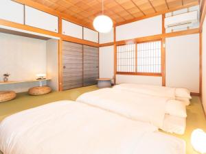Postel nebo postele na pokoji v ubytování 平田屋 昭和の間 -Hirataya Showa- 父母ケ浜4分