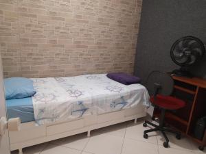 a bedroom with a bed and a brick wall at Pensionato Real Masculino in Jandira