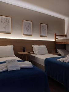a hotel room with two beds with blue sheets at Pousada Bem te vi in Bragança Paulista +43 photos