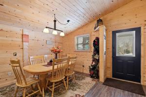 a wooden dining room with a table and chairs at Huckleberry Hollow in Rea