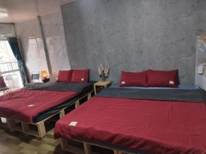 2 posti letto in una camera con lenzuola rosse di H2 homestay phố cổ check-in tự động 03 a Hanoi Altre 38 foto