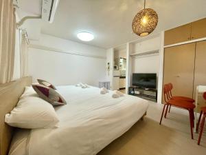 a bedroom with a large white bed and a table at YMK Oshiage 5B in Tokyo