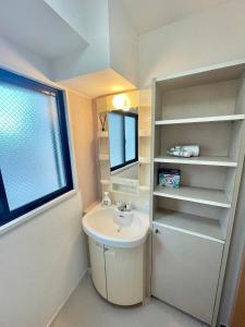 a small bathroom with a sink and a mirror at YMK Oshiage 5B in Tokyo