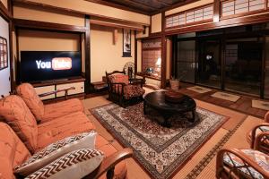 a living room with a couch and a tv at nostalgia2 ノスタルジア2 in Yokosuka