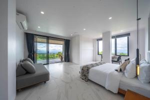 a bedroom with a bed and a couch and windows at Gandum Uluwatu Luxury Boutique Stay - Gandum Villa Complex in Uluwatu +83 photos
